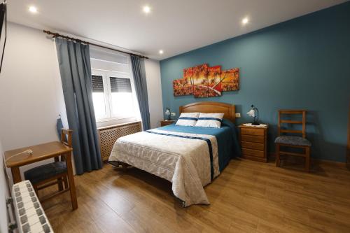 sypialnia z niebieskimi ścianami, łóżkiem i oknem w obiekcie LUZ DE PRADA w mieście Puebla de Sanabria