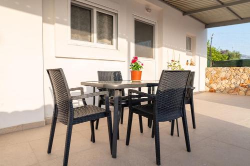 un patio con mesa y 4 sillas en Zografia - Charming House near the coast en Cos