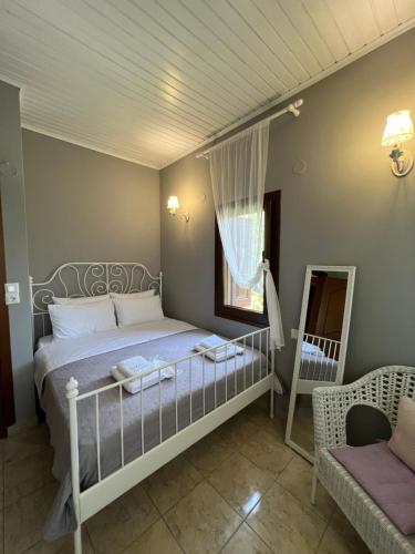 1 dormitorio con cama, ventana y silla en aellia home, en Tsagkarada