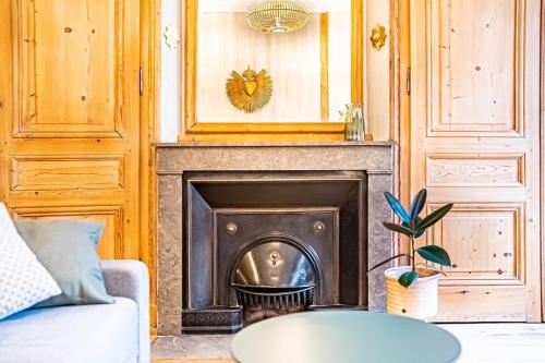 ein Wohnzimmer mit einem Kamin und einem Sofa in der Unterkunft Le St Blandine-magnifique 4 pers- Carnot Perrache in Lyon