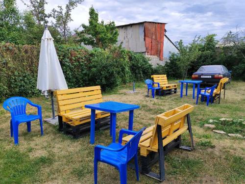 a group of benches and tables and an umbrella at Nomadstan CAPSULE Hostel in Karakol