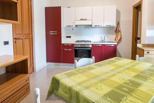 a kitchen with a table and a kitchen with red cabinets at SE010 - Senigallia, bilocale sul mare con spiaggia in Senigallia
