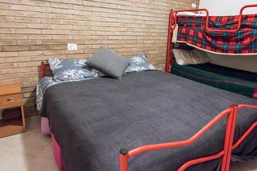 a bed in a room with a brick wall at SE010 - Senigallia, bilocale sul mare con spiaggia in Senigallia
