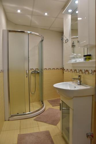 y baño con ducha y lavamanos. en Paradise Apartment - Breathtaking View en Veliko Tŭrnovo