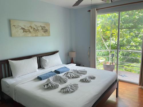a bedroom with a large white bed with a window at Kata Top View by Lofty in Kata Beach