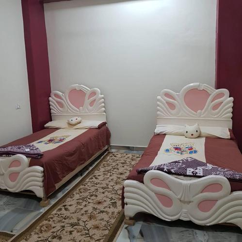 two beds sitting next to each other in a room at El radwan in Jazīrat al ‘Awwāmīyah