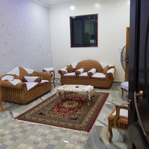 a living room with two couches and a table at El radwan in Jazīrat al ‘Awwāmīyah