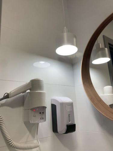 a mirror and a hair dryer on a wall at Villa Rey Spa & Hotel in Vila de Rei