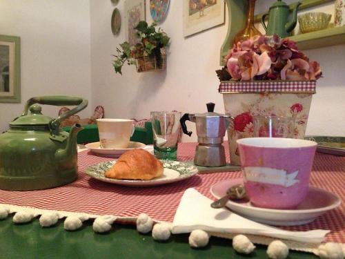 een tafel met een groene waterkoker en een bord eten bij Casa Mariuccia in Carloforte