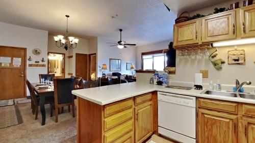 a kitchen with wooden cabinets and a dining room at CC102 Buffalo Village in Silverthorne
