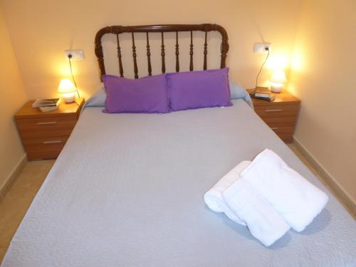 - un lit avec 2 oreillers et des serviettes dans l'établissement Casa rural Butaka, à Alcalá del Júcar