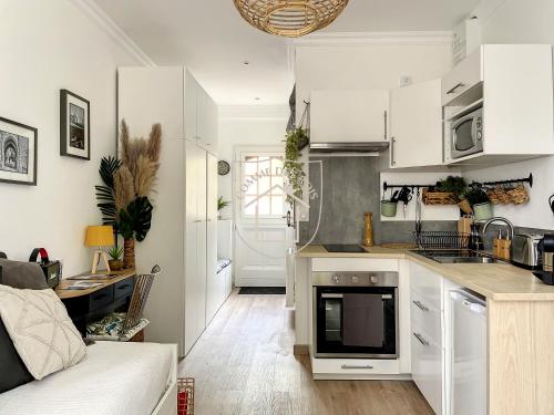uma cozinha com armários brancos e uma sala de estar em Le Cachot des Rois em Dourdan