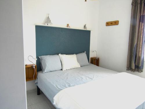 een slaapkamer met een bed met een blauw hoofdeinde bij Appartement vue exceptionnelle sur les canaux - Wi-Fi fibre haut débit in Empuriabrava