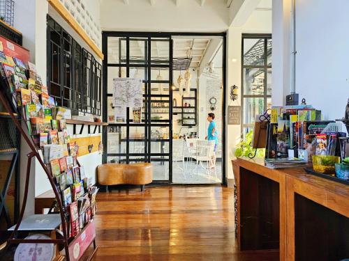 a room with a book store with a person in the background at Sherloft Home & Hostel in Chiang Mai