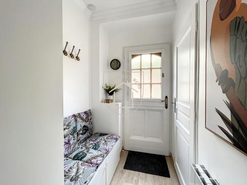 a hallway with a white door and a couch at Le Cachot des Rois in Dourdan