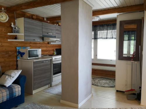 a kitchen with a stove and a microwave at Kallioranta in Lestijärvi