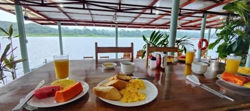 a table with plates of breakfast foods and orange juice at Casa Marbella in Tortuguero
