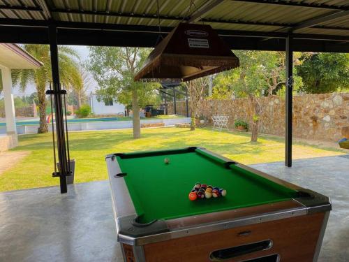a pool table sitting on a patio with a hood at Arom Pool Villa Pattaya 1 in Na Jomtien