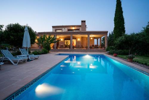 a swimming pool in front of a house at Villa Marín Toledo in Las Nieves