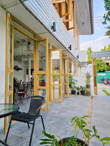 a patio with chairs and tables in a building at SherVa101 Home and Hostel in Chiang Mai