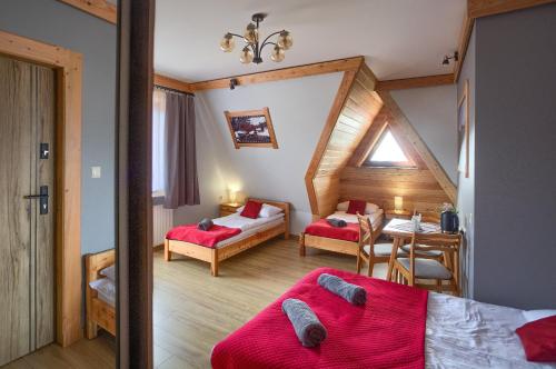 a bedroom with two beds and a table in a room at U Studniara in Murzasichle