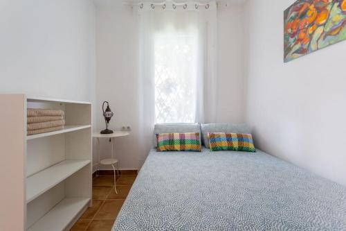a bedroom with a bed with two pillows on it at Apartamento en playa de castelldefels. Ubicación inmejorable! in Castelldefels