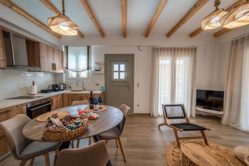 uma cozinha e sala de jantar com mesa e cadeiras em Epithea Suites Kythnos 1 με ιδιωτική πισίνα em Kythnos