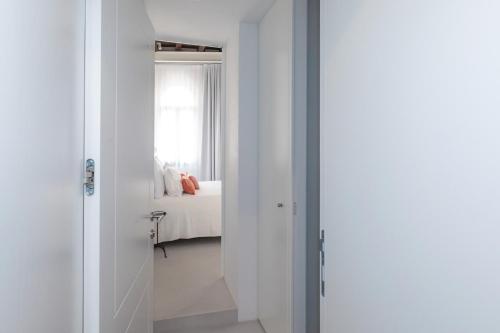Una habitación blanca con una cama y una ventana. en Palazzo Basilisco Luxury Suite, en Rovinj