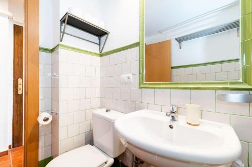 y baño con lavabo, aseo y espejo. en Wekey Homes Albaicin, A los Pies de la Alhambra, en Granada