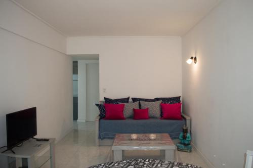 sala de estar con sofá gris y almohadas rojas en Departamento Meir 12 céntrico con cochera a metros del Casino en Mar del Plata