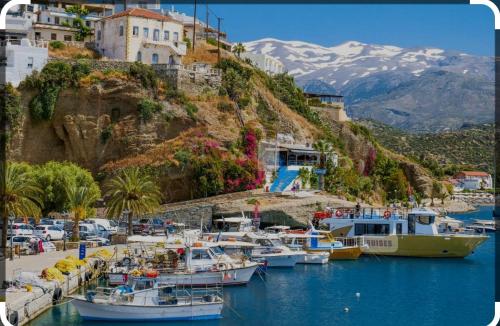 Ein Haufen Boote, die in einem Hafen mit Bergen angedockt sind. in der Unterkunft THROUBI VILLA in Agia Galini