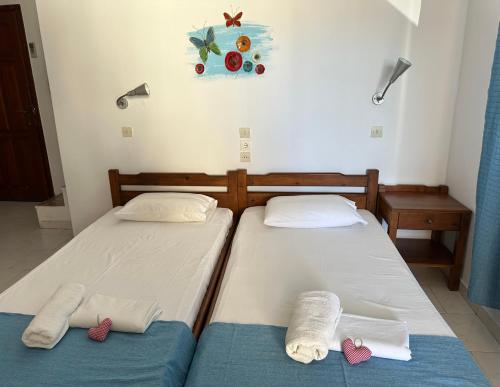 two beds in a room with towels on them at BONATSA ROOMS in Palaiochóra