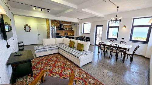 a living room with a couch and a dining room at Alma Villa Guest House - Bosteri in Bosteri