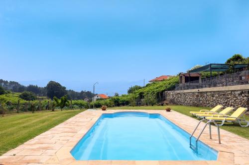 una piscina en un patio con 2 sillas en Casa do Desassossego, en Monção