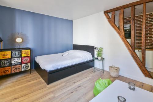 une chambre avec un lit et un mur bleu dans l'établissement Studio Rostène - Welkeys, à Paris