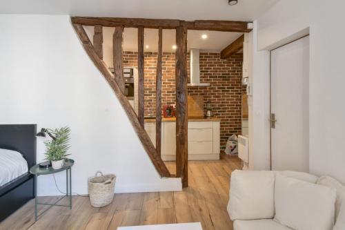 un salon avec un canapé et une cuisine dans l'établissement Studio Rostène - Welkeys, à Paris