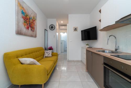 a living room with a yellow couch in a kitchen at Apartment Leo in Trogir