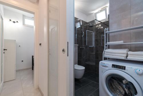 a washing machine in a bathroom with a shower at Apartment Leo in Trogir