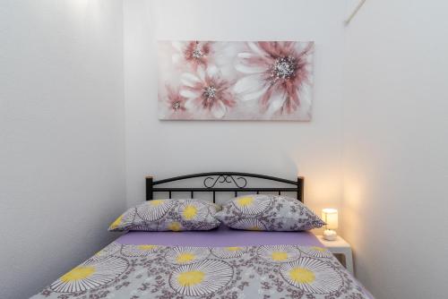 een slaapkamer met een bed en een schilderij aan de muur bij Apartment Leo in Trogir