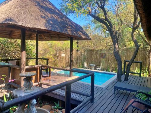 a deck with a pavilion and a swimming pool at Hoedspruit Raptors Lodge N16 in Hoedspruit