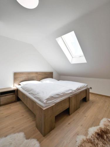 a bedroom with a large bed with a skylight at Penzion SALAŠ in Salaš