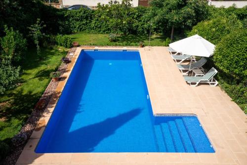 an overhead view of a swimming pool with two chairs and an umbrella at Villa Marín Toledo in Las Nieves