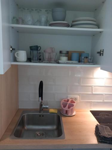 - une cuisine avec un évier et une étagère avec de la vaisselle dans l'établissement Room and terrace, à Krk