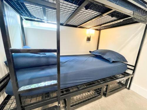 a bunk bed with blue sheets and pillows on it at ITH Santa Barbara Beach Hostel in Santa Barbara