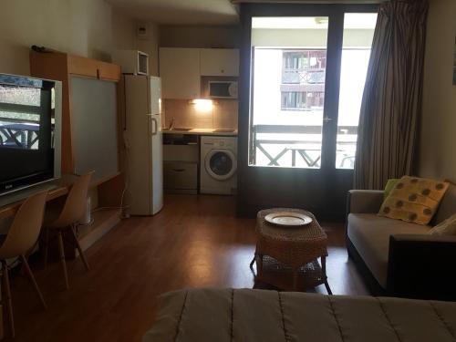 un salon avec un canapé et une table et une cuisine dans l'établissement Studio à Brides-les-Bains, 4 pers, balcon, parking couvert, proche centre et thermes - FR-1-512-272, à Brides-les-Bains