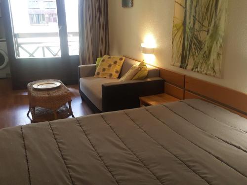 une chambre d'hôtel avec un lit et un canapé dans l'établissement Studio à Brides-les-Bains, 4 pers, balcon, parking couvert, proche centre et thermes - FR-1-512-272, à Brides-les-Bains