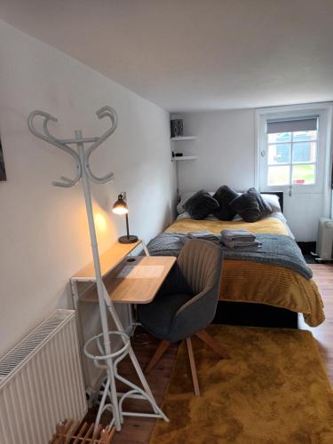 a bedroom with a bed and a desk with a lamp at The Annexe in Rothwell