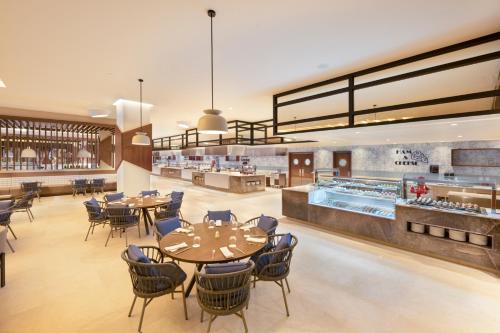 a restaurant with tables and chairs and a cafeteria at Royalton Splash Riviera Cancun, An Autograph Collection All-Inclusive Resort in Cancún