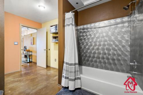 a bathroom with a shower with a shower curtain at Elevated Route 66 ABQ Penthouse- An Irvie Home in Albuquerque