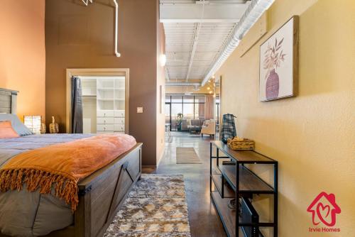 a bedroom with a large bed and a hallway at Elevated Route 66 ABQ Penthouse- An Irvie Home in Albuquerque